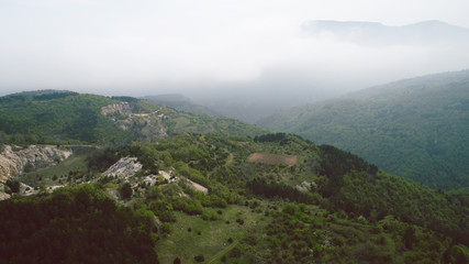 Fototapeta na wymiar Aerial View With Mountain Road And Heavy Mist At The Background 