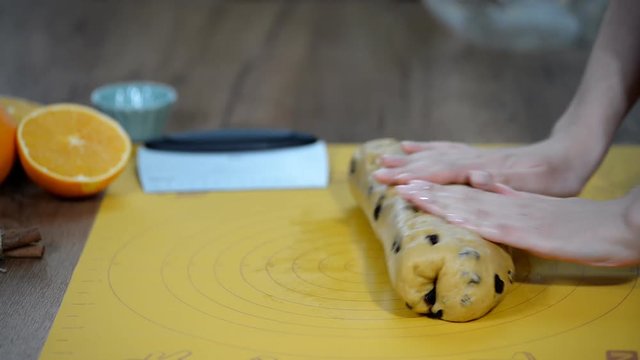 Woman's hands knead dough on table