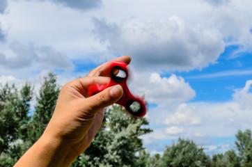 Red fidget spinner in female hand