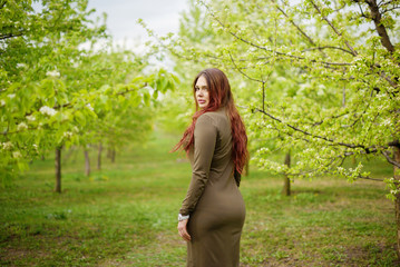 lovely girl in spring blossoming garden