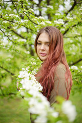 Fototapeta na wymiar lovely girl in spring blossoming garden