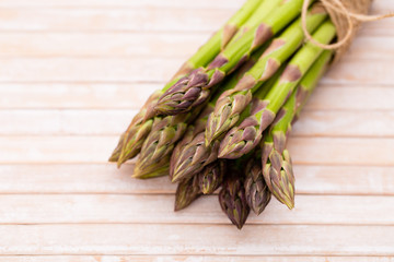 Bunch of fresh asparagus on wooden table.