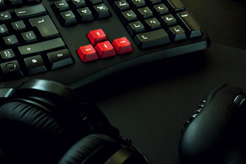gaming keyboard, headphones and mouse on black table