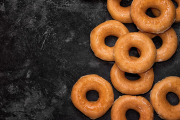 group of donuts on a black cement background, top view with copy space