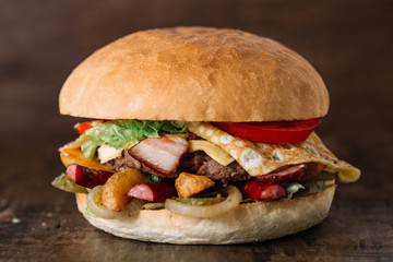 fresh tasty burger with omelet on wooden table