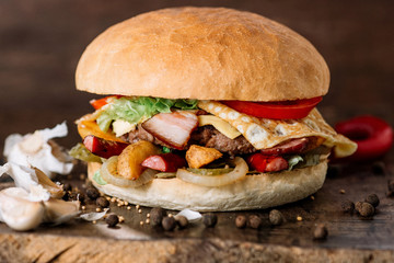 fresh tasty burger with omelet on wooden table