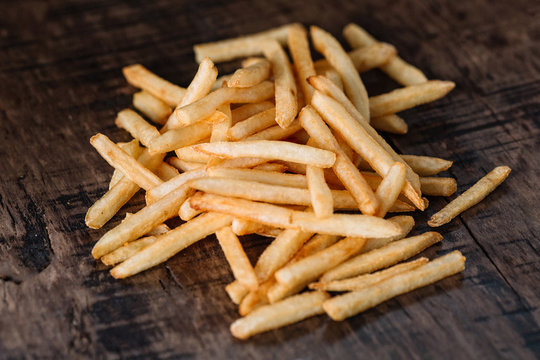 French fries potatoes on wood background