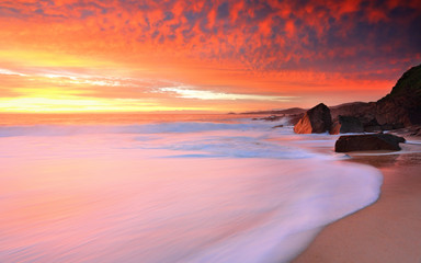 Foamy white seas and vivid sunrise