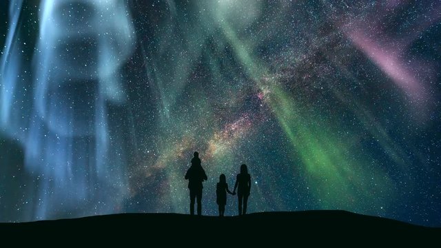 The family standing against the starry sky with a northern light. time lapse