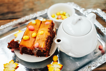 Autumn sweet dessert. Pumpking chocolate cake with dragee and tea