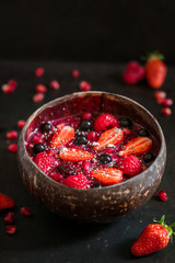 Smoothie bowl aux fruits rouges sur fond noir