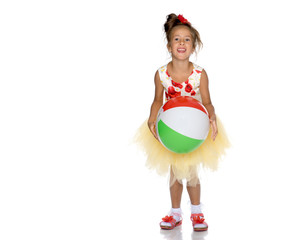 Little girl is playing with a ball