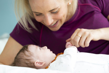 beautiful blond mother with her 3 month old baby wearing a amber necklace