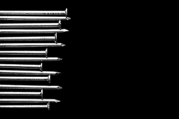 Background of isolated nails on black and space for text