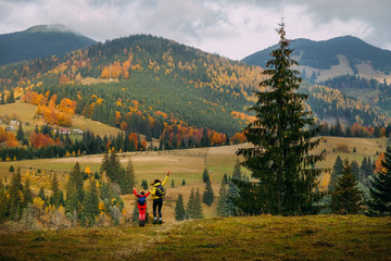 Fototapeta na wymiar Mom and her kid at Carpathian countryside in Autumn
