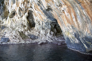 Interior of a natural sea cave, Cilento, Italy. The reddish sediments are due to the zinc oxide.