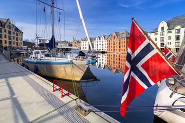 Yacht with the flag of Norway in Alesund town marina.