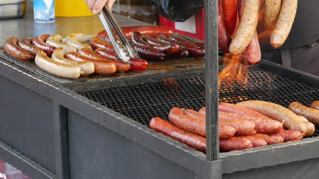 Different types of sausage grilled on fire. Street food with tasty grilled sausages.