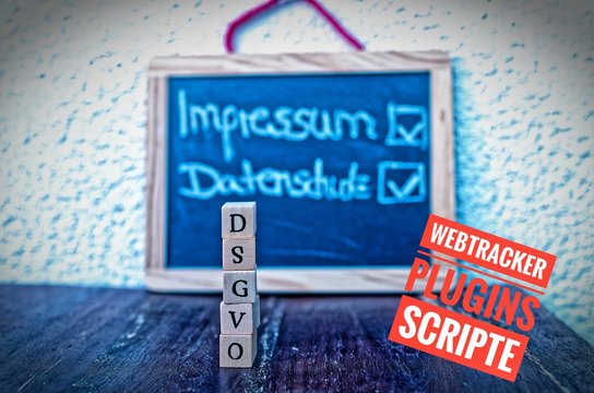Baukl&ouml;tze mit der Aufschrift DSGVO (Datenschutzgrundverordnung)  und einer Tafel mit der Aufschrift Impressum und Datenschutz und Webtracker Plugins Scripte