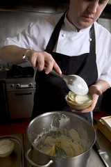 Professional chef at work in a restaurant kitchen, gratin dauphinois