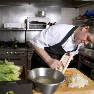 Professional Chef At Work Slicing In A Restaurant Kitchen