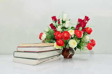 Old book with red roses bouquet The concept of love education.