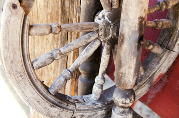 Old distaff spinning wheel in the yard of a country house. The concept of preservation of traditional crafts, obsolete technologies