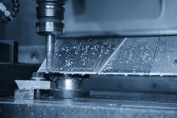 The CNC milling machine cutting the aluminum automotive part with the solid ball endmill in the light blue scene.