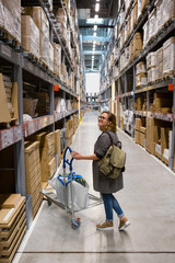 Woman looking for goods in the self-service warehouse