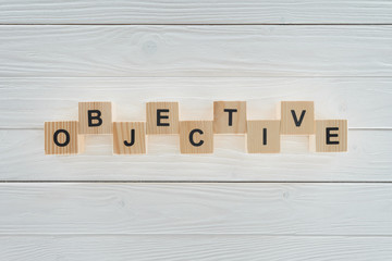 top view of objective word made of blocks on white wooden surface
