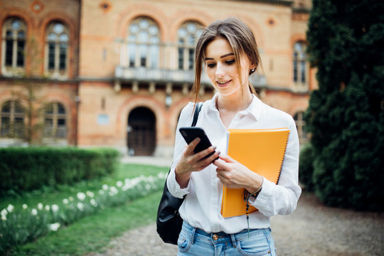 Student girl read something on smartphone outdoor in the campus
