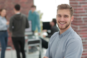 Fototapeta premium Successful young business man standing with his colleagues in b