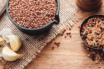 Buckwheat with spices on natural wooden background