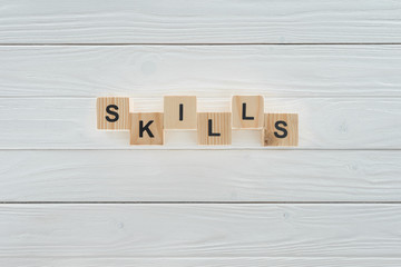 top view of skills inscription made of blocks on white wooden surface