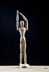 Wooden mannequin in a pose standing with raised hands