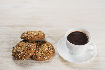 Cup of hot chocolate and Homemade cookies with seeds and nuts on white wooden background