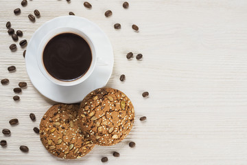 Cup of hot chocolate and Homemade cookies with seeds and nuts on white wooden background