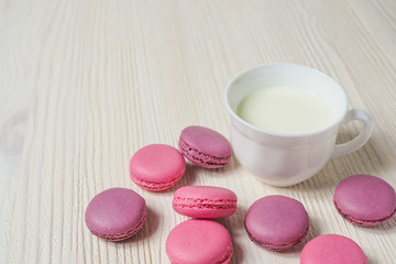 pink cookies makaroon and Cup on white wooden background