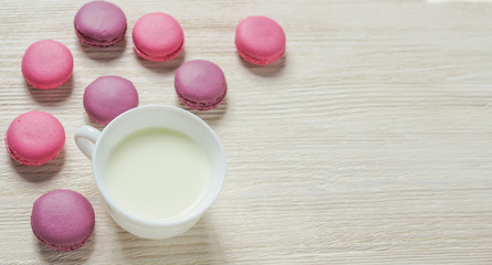 pink cookies makaroon and Cup on white wooden background