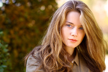 Portrait of beautiful young woman with blonde hair in autumn