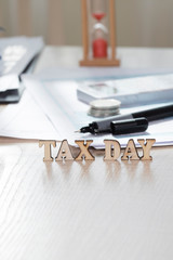 Word TAX DAY composed of wooden letters. Closeup