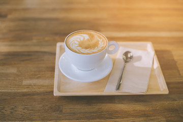 A Cup of hot latte art coffee on wooden table