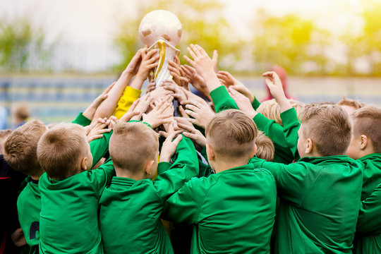 Kids Celebrating Soccer Victory. Young Football Players Holding Trophy. Boys Celebrating Sports Championship. Winning Team of Sport Tournament for Kids Children