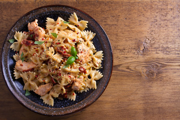 Sun dried tomato pasta with chicken and basil in creamy mozzarella sauce. View from above, top studio shot