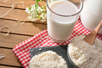 Composition with rice drink in containers in the field elevated