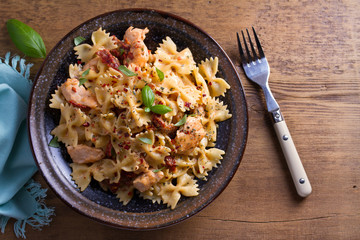 Sun dried tomato pasta with chicken and basil in creamy mozzarella sauce. View from above, top studio shot