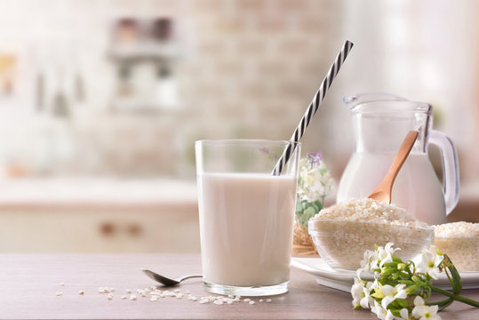 Rice milk and rice in containers in rustic kitchen front