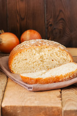 Sliced homemade onion bread on a napkin. Wooden background. Rustic style. Top view and copy space.