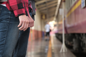 man & woman with backpack waiting for train at railway station. loving couple traveler travel together on holiday