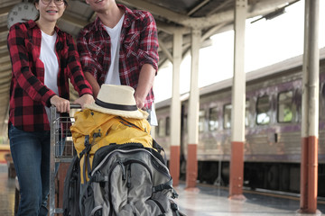 man & woman with backpack on baggage trolley at train station. loving couple traveler travel together on holiday